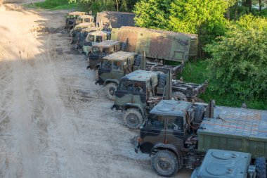 Askeri nakliye kamyonları savaş meydanında arka arkaya park etmiş.