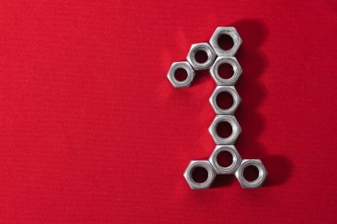 Bir numara, kırmızı kumaş arka planda çelik fındıklardan yapılmış.