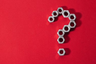 Soru işareti, kırmızı kumaş arka planda çelik fındık ile yapılmış, reklam metni, kılık değiştirme, güç ve dayanıklılık için yer bırakması, grafik reklam konsepti