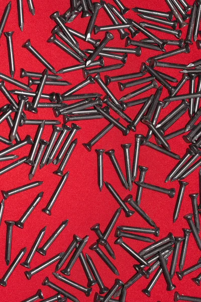 Black Steel Nails Red Background Randomly Scattered — Stock Photo, Image