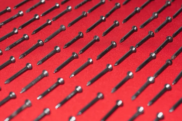 Muchos Clavos Acero Negro Sobre Fondo Rojo Dispuestos Diagonal Perfectamente — Foto de Stock