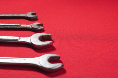 Anahtarlar, paslı, kırmızı arka planda yükselen sırayla reklam metni için boşluk bırakıyor. Yapı araçları