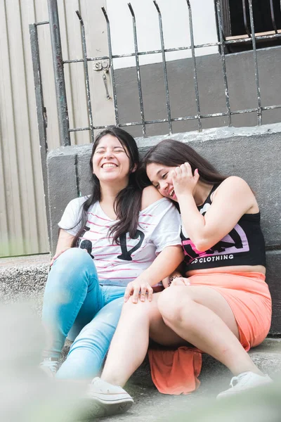 Happy Latin Girls Laughing Sitting Sidewalk Outdoors City Friendship Loyalty — Stock Photo, Image