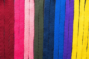 Siyah tahta üzerindeki renkli ayakkabı bağcıklarının arka planı, dikey olarak düzenlenmiş, mükemmellik kavramı, reklam metinleri için yer bırakması