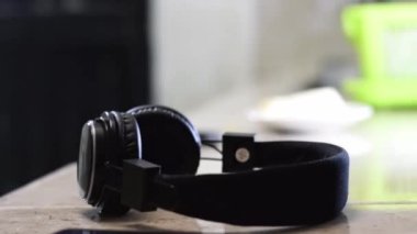 Genç bir adamın mutfakta bir bıçakla parmağını kesmesi ya da yaralanması dramatize ediliyor. Peynir kesmek eli keser, kulaklıklar arka planda. konsantrasyon ve müzik konsepti