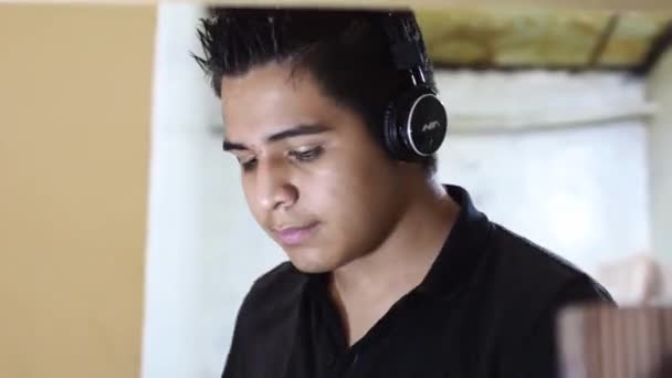 Latin American Teenager Listening Music Kitchen Headphones While Slicing Knife — Stock Video