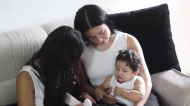 Bebeğinizi cesaretlendirmek: Latin anneler bebeğini kucağında tutarken bebeklerinin ayaklarıyla oynuyorlar..