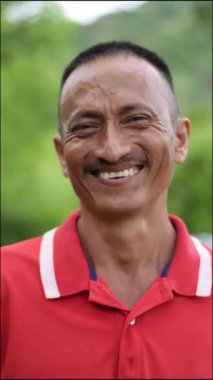 Kameraya bakarken gülümseyen Kolombiyalı yerli bir adamın yüzünü yakından çek.