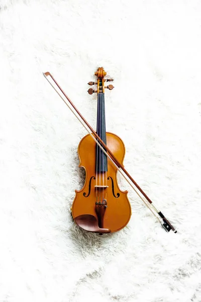 violin and bow on fluffy white carpet background