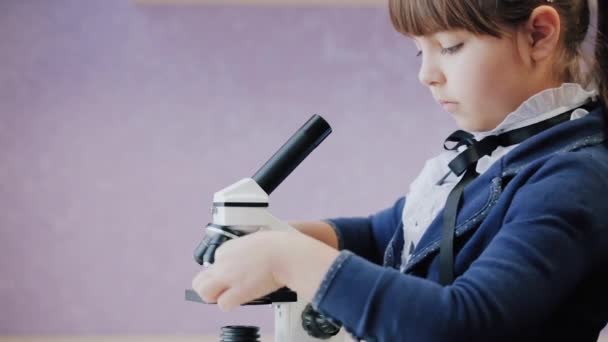 Little girl attentively looks into microscope — Stock Video