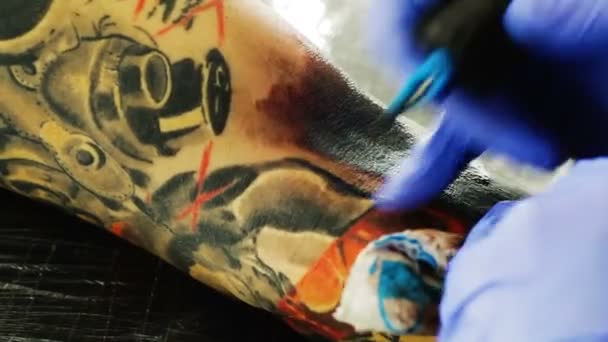 Татуировка на теле. Татуировщик делает татуировку в студии — стоковое видео