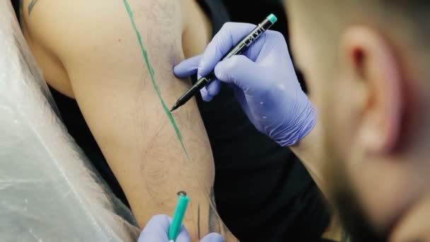 Tattoo Master disegna una linea in marcatore verde sulla spalla — Video Stock