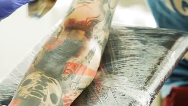 Dövme sanatçısı dövme için diğer erkek koyar. — Stok video