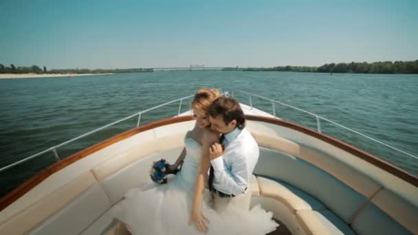 La novia y el novio en un barco flotando en el río . — Vídeo de stock