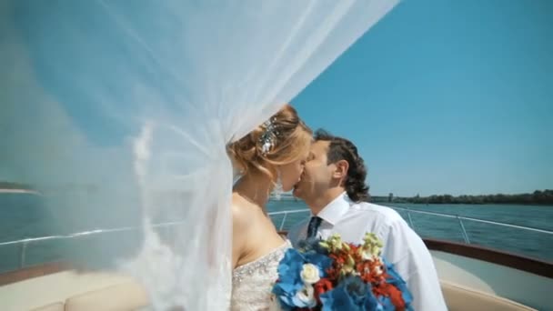 Hochzeitsschleier entwickelten sich im Wind. ein Liebespaar segelt auf einer Jacht. — Stockvideo