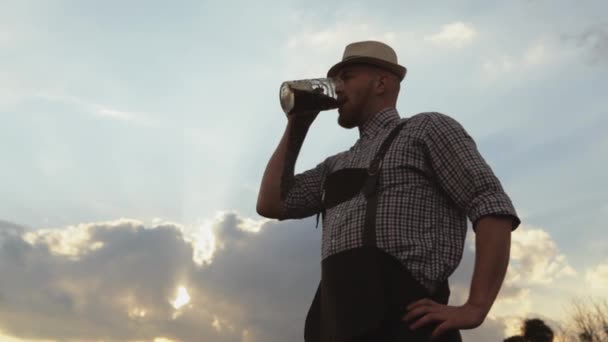 Чоловік дегустує пиво на тлі заходу сонця . — стокове відео