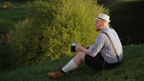 Bavarian sitting on a hill near the cliff. — Stock Video