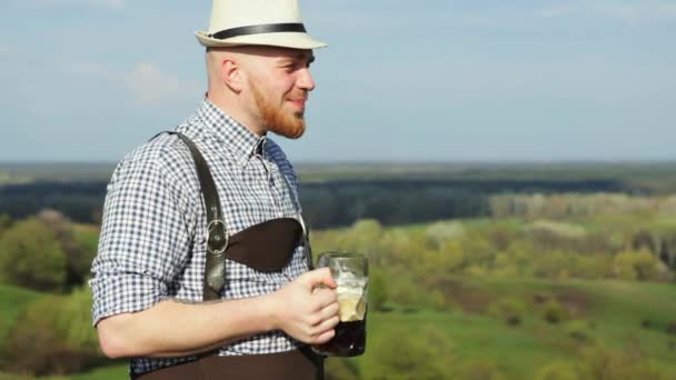 Człowiek w wiosenny dzień, ciesząc się pyszne ciemne piwa. — Wideo stockowe