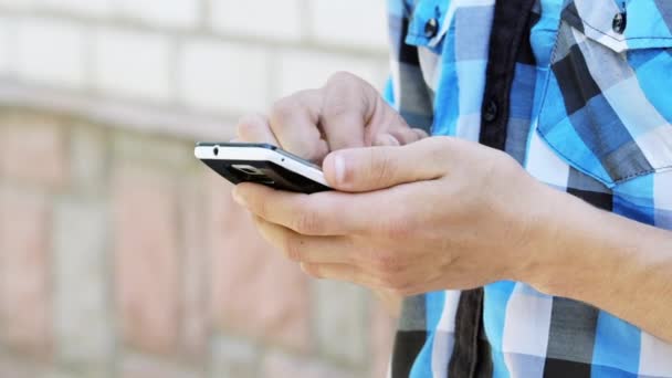 Человек набирает SMS на свой мобильный телефон — стоковое видео