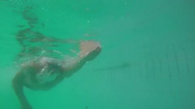 Adam kameraya doğru Yüzme sualtı manzarası. Ağır çekimde.