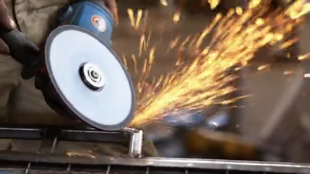 Handheld shot of carpenter grinding metal in manufacturing — Stock Video