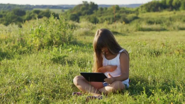 Muggen hebben invloed op een klein meisje spelen op een digitale tablet in de natuur. — Stockvideo