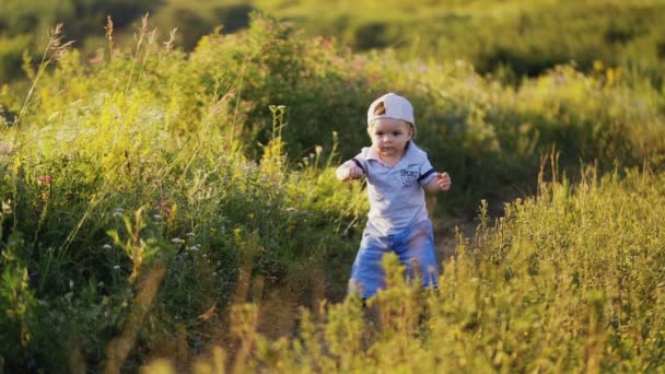 Niño emocional en la naturaleza dando sus primeros pasos . — Vídeos de Stock