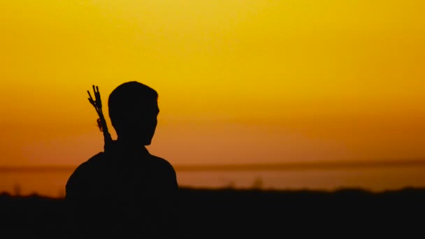 Silhouette de tir à l'arc, coucher de soleil derrière l'archer — Video