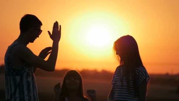 Молодий брат і дві сестри на заході сонця — стокове відео