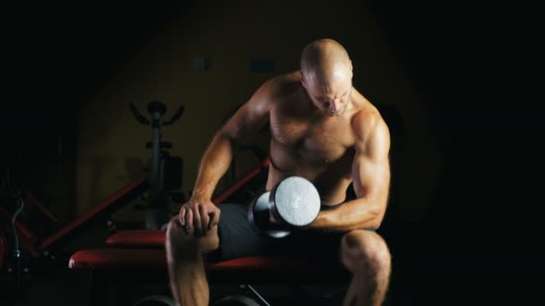 Atlet mengangkat dumbel berat di gym . — Stok Video