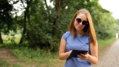 Bir tablet elinde bulunan Parkı yürüme ile çekici kız.