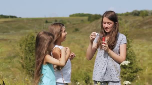 Ragazze nel parco soffiando bolle con bacchetta bolla — Video Stock