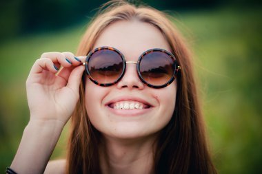 Güneş gözlüklü esmer güzel yakın çekim portre yuvarlak gözlük.