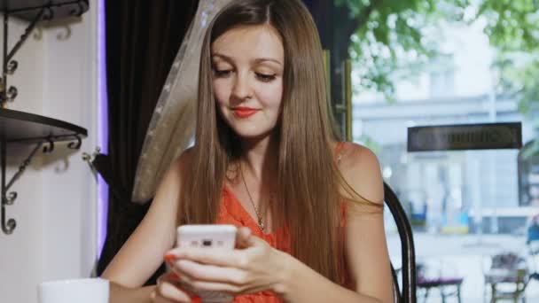 Ελκυστικό κορίτσι στο κόκκινο μιλώντας σε ένα smartphone. — Αρχείο Βίντεο
