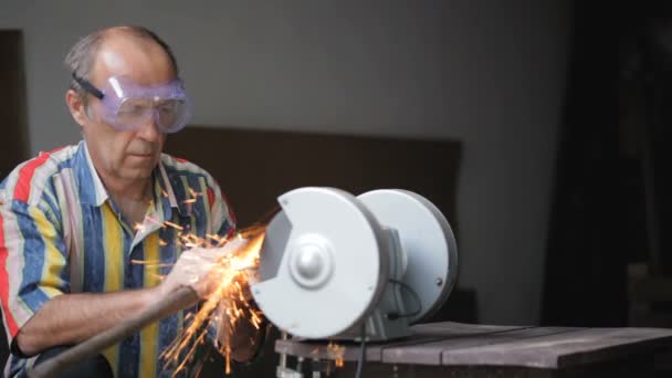 Worker man sharpen ax tool at industrial machine — Stock Video