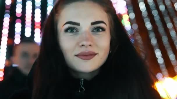 Junge fröhliche Frau Portrait Lächeln und Blick in die Kamera, Bokeh von Weihnachtsgirlanden Lichter — Stockvideo