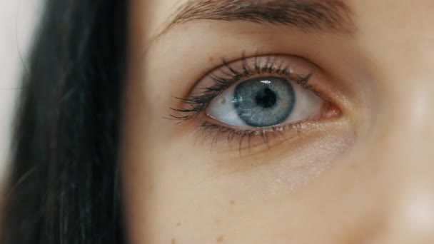 Close-up van vrouwelijke oogopening met mooie blauwe iris — Stockvideo