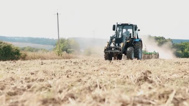 Oude tractor ploegt het veld voor het zaaien van tarwe. Gecultiveerd landwerk in het veld. — Stockvideo