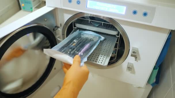 Travailleur de laboratoire mettant des instruments médicaux dans la machine de stérilisation autoclave à vapeur — Video
