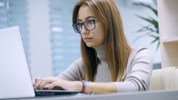 Słodka kobieta pracująca na laptopie w okularach, wpisująca tekst w biurze, pracownik w pracy na komputerze. — Wideo stockowe