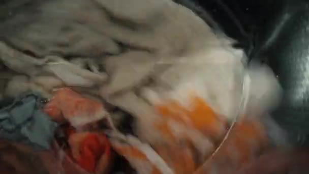 Close-up van gekleurde dingen en handdoeken wassen in de wasmachine — Stockvideo