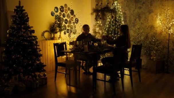 Silhouette of a loving married couple having dinner on Christmas eve, exchanging gifts and drinking champagne — Stock Video