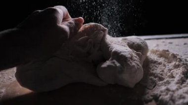 Dişi eller hamuru yavaşça yakın çekimde yoğurur.