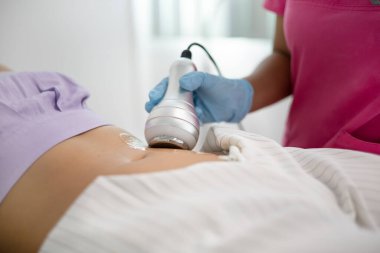 Karın bölgesindeki kas tanımı için titreşim tedavisi