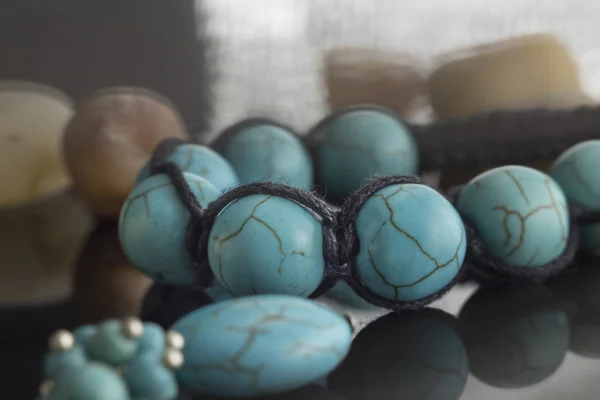 Karanlık bir yüzey üzerinde turkuaz bilezik