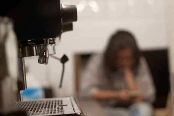 Bekleyen bir kahve makinesi kahve değirmenini işleyip lezzetli bir bardak espresso üretmek için kullanılır..