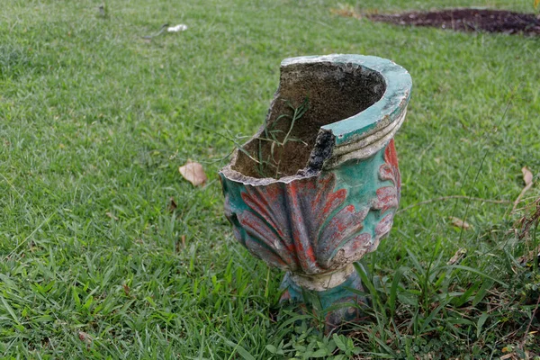 A flower pot that broke from a long period of disuse by its owner.