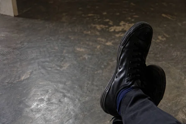 Bir adam dinleniyor. Parlak siyah ayakkabılarla günün tadını çıkarıyor..