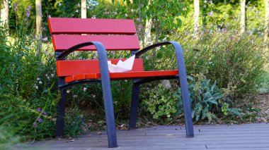 Kırmızı parktaki bankta kağıt tekne