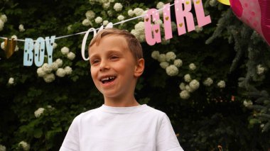            Bir kız kardeşi olacağını öğrenen bir çocuğun yüzü sevinçle parlıyor. Cinsiyet belirleme partisi                      